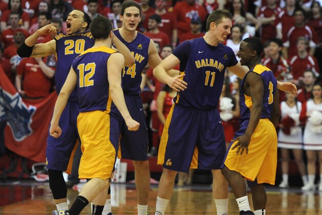 Albany' Gary Johnson (20), Peter Hooley (12), John Puk (44), Luke Devlin (11) and  DJ Evans (3) celebrate after Albany beat Stony Brook 69-69 in an NCAA college basketball game to win the championship of the America East Conference tournament Saturday, March 15, 2014, in Stony Brook, N.Y. (AP Photo/Kathy Kmonicek)