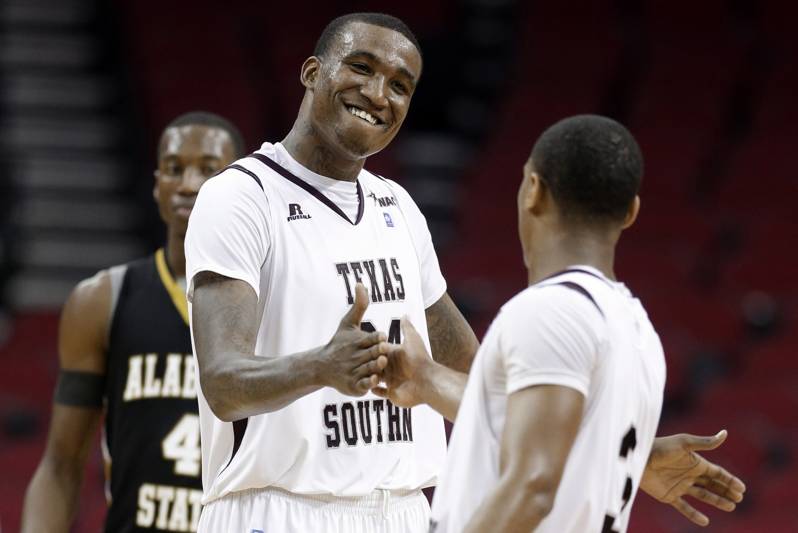 Texas Southern's Aaric Murray (24) celebrates with Madarious Gibbs (3) after Texas Southern defeated Alabama State in an NCAA college basketball game in the semifinals of the Southwestern Athletic Conference men's tournament Friday, March 14, 2014, in Houston. Texas Southern won 73-61. (AP Photo/David J. Phillip)