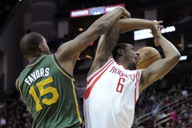 Utah Jazz's Derrick Favors (15) knocks the ball away from Houston Rockets's Terrence Jones (6) in the first half of an NBA basketball game Monday, March 17, 2014, in Houston. (AP Photo/Pat Sullivan)