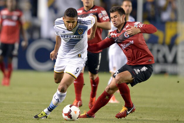 Mar 12, 2014; Carson, CA, USA; Los Angeles Galaxy forward Samuel (9) and Club Tijuana defender Elo Castro Guadarrama (54) battle for ball in Champions League match at StubHub Center. The Galaxy defeated Club Tijuana 1-0. Mandatory Credit: Kirby Lee-USA TODAY Sports