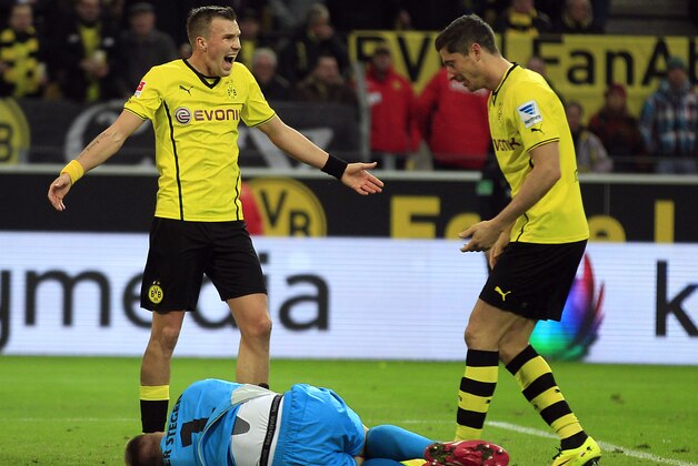 Dortmund's Kevin Grosskreutz, left, and Dortmund's Robert Lewandowski of Poland react while Moenchengladbach's goalkeeper Marc-Andre ter Stegen lies on the pitch during the German first division Bundesliga soccer match between BvB Borussia Dortmund and VfL Borussia Moenchengladbach in Dortmund, Germany, Saturday, March 15, 2014. (AP Photo/Frank Augstein)