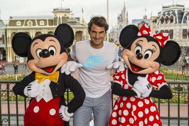 LAKE BUENA VISTA, FL - MARCH 17:  In this handout photo provided by Diseny Parks, tennis legend Roger Federer poses with Mickey and Minnie Mouse at the Magic Kingdom park March 17, 2014 in Lake Buena Vista, Florida.  The Swiss-born Federer holds the men's world record for most Grand Slam tournaments won, 17, and has spent 302 weeks as the world's number-one ranked male tennis player. (Photo by Matt Stroshane/Disney Parks via Getty Images)