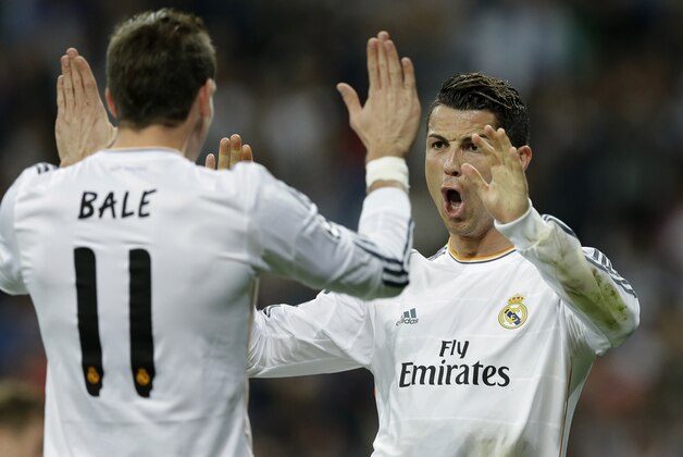 Real's Cristiano Ronaldo, right, celebrates with Real's Gareth Bale after scoring during a Champions League round of 16, second leg, soccer match between Real Madrid and Schalke 04 at the Santiago Bernabeu stadium in Madrid, Tuesday March 18, 2014. (AP Photo/Paul White)