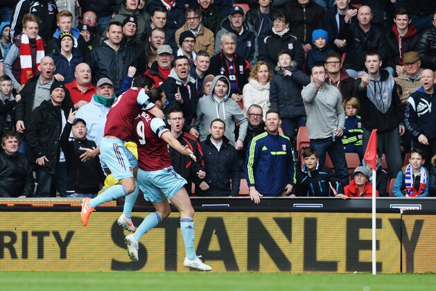 STOKE ON TRENT, ENGLAND - MARCH 15:  Andy Carroll of West Ham United celebrates in front of Stoke City fans with James Tomkins of West Ham United as he scores their first goal during the Barclays Premier League match between Stoke City and West Ham United at Britannia Stadium on March 15, 2014 in Stoke on Trent, England.  (Photo by Ross Kinnaird/Getty Images)