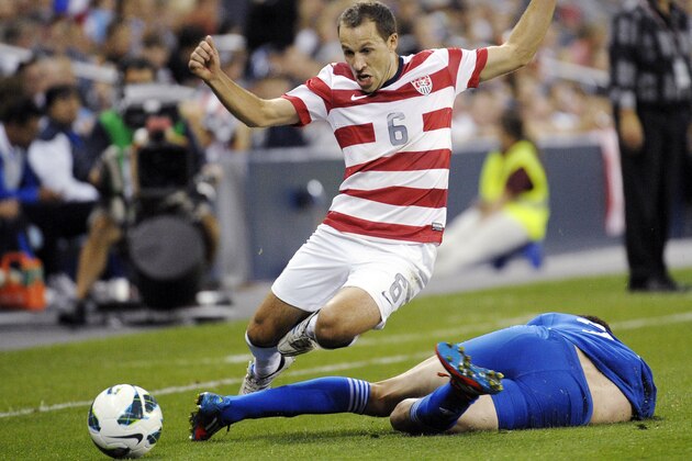 United States defender Steven Cherundolo (6) leaps over a sliding Guatemala forward Minor Lopez (22) during the second half of a World Cup qualifying soccer match in Kansas City, Kan., Tuesday, Oct. 16, 2012. The United States won 3-1. (AP Photo/Reed Hoffmann)