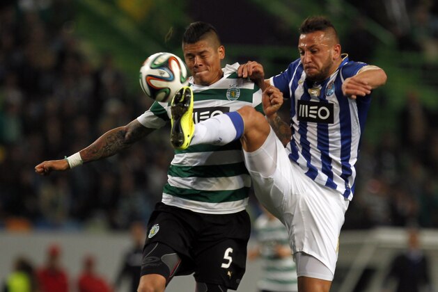 Porto's Nabil Ghilas, from Algeria, tussles for the ball with Sporting's Marcos Rojo, left, from Argentina, during the Portuguese league soccer match between Sporting and Porto at Sporting's Alvalade stadium, in Lisbon, Sunday, March 16, 2014. Sporting won 1-0. (AP Photo/Francisco Seco)