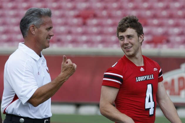 In this photo taken Sunday, Aug. 7, 2011, Louisville quarterback coach Shawn Watson and quarterback Will Stein (4) walk onto the field for a photo session prior to their NCAA college football season in Louisville, Ky. (AP Photo/Ed Reinke)