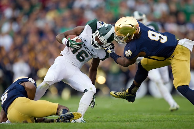 Sep 21, 2013; South Bend, IN, USA; Notre Dame Fighting Irish cornerback KeiVarae Russell (6) and linebacker Jaylon Smith (9) tackle Michigan State Spartans wide receiver Aaron Burbridge (16) in the fourth quarter at Notre Dame Stadium. Notre Dame won 17-13. Mandatory Credit: Matt Cashore-USA TODAY Sports