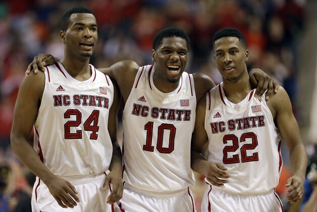 North Carolina State players, from left, T.J. Warren (24), Lennard Freeman (10), and Ralston Turner (22), celebrate during the second half of a second round NCAA college basketball game against Miami at the Atlantic Coast Conference tournament in Greensboro, N.C., Thursday, March 13, 2014. North Carolina State won 67-58. (AP Photo/Gerry Broome)