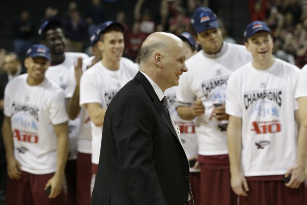 While his team watches, Saint Joseph head coach Phil Martelli smiles during an awards ceremony after an NCAA college basketball game against VCU in the championship round of the Atlantic 10 Conference tournament at the Barclays Center in New York, Sunday, March 16, 2014. St. Joseph's defeated VCU 65-61. (AP Photo/Seth Wenig)