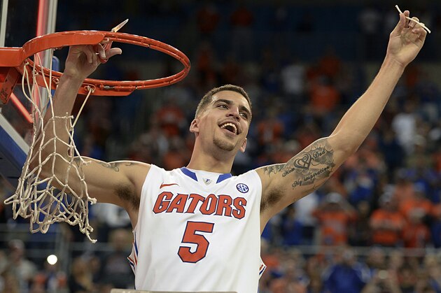 Florida guard Scottie Wilbekin (5) holds up a piece of the net after the Gators became the first team in Southeastern Conference history to go 18-0 in league pla, Saturday, March 8, 2014 in Gainesville, Fla.    Florida defeated Kentucky 84-65 Saturday in an NCAA college basketball game. (AP Photo/Phil Sandlin)