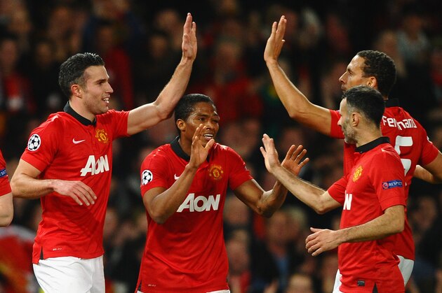 MANCHESTER, ENGLAND - MARCH 19:  Robin van Persie of Manchester United celebrates scoring the second goal with his team-mates during the UEFA Champions League Round of 16 second round match between Manchester United and Olympiacos FC at Old Trafford on March 19, 2014 in Manchester, England.  (Photo by Laurence Griffiths/Getty Images)