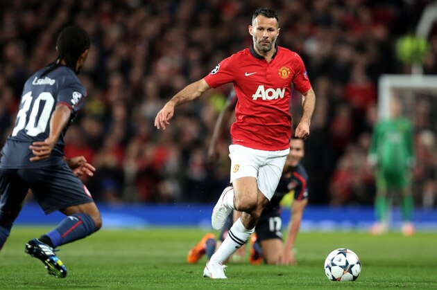 Olympiakos' Leandro Salino, left, competes for the ball with Manchester United's Ryan Giggs during their Champions League last 16 second leg soccer match at Old Trafford Stadium, Manchester, England, Wednesday, March 19, 2014. (AP Photo/Jon Super)