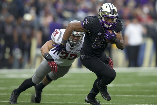 SEATTLE, WA - NOVEMBER 29: Bishop Sankey #25 of Washington rushes the ball as Tana Pritchard #33 of Washington State tries to make a tackle during the second half of a game at Husky Stadium on November 29, 2013 in Seattle, Washington. Washington won the game 27-17. Sankey broke the University of Washington  all-time record for rushing touchdowns and total rushing yardage. (Photo by Stephen Brashear/Getty Images)