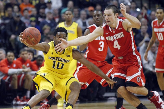 Michigan guard Derrick Walton Jr. (10) and Ohio State guard Aaron Craft (4) chase after a loose ball in the first half of an NCAA college basketball game in the semifinals of the Big Ten Conference tournament Saturday, March 15, 2014, in Indianapolis. (AP Photo/Kiichiro Sato)
