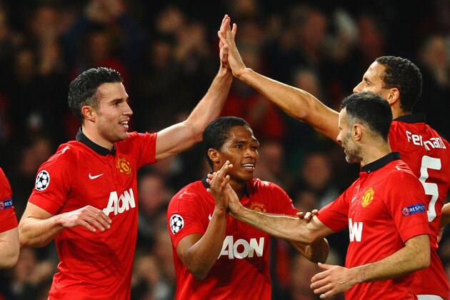 MANCHESTER, ENGLAND - MARCH 19:  Robin van Persie of Manchester United celebrates scoring the second goal with his team-mates during the UEFA Champions League Round of 16 second round match between Manchester United and Olympiacos FC at Old Trafford on March 19, 2014 in Manchester, England.  (Photo by Laurence Griffiths/Getty Images)