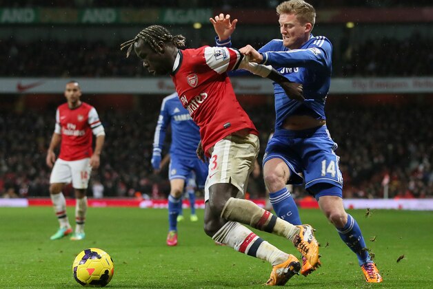 Arsenal's Bacary Sagna, left holds off the challenge of Chelsea's Andre Schuerrle during their English Premier League soccer match between Arsenal and Chelsea at the Emirates stadium in London, Monday, Dec. 23, 2013. (AP Photo/Alastair Grant)