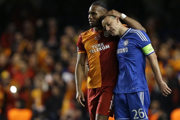 Galatasaray's Didier Drogba, left, embraces Chelsea's John Terry at the end of the Champions League round of 16 second leg soccer match between Chelsea and Galatasaray at Stamford Bridge stadium  in London Tuesday, March 18, 2014. (AP Photo/Kirsty Wigglesworth)