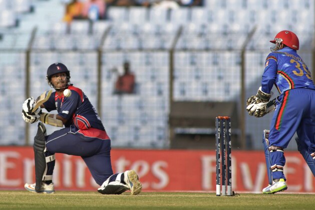 Nepal's Subash Khakurel plays a shot as Afghanistan's wicketkeeper Mohammad Shahzad, right, watches during their ICC Twenty20 Cricket World Cup match in Chittagong, Bangladesh, Thursday, March 20, 2014 . (AP Photo/Bikas Das)