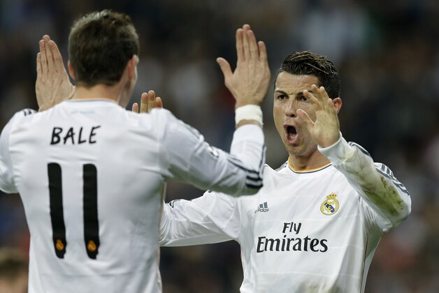 Real's Cristiano Ronaldo, right, celebrates with Real's Gareth Bale after scoring during a Champions League round of 16, second leg, soccer match between Real Madrid and Schalke 04 at the Santiago Bernabeu stadium in Madrid, Tuesday March 18, 2014. (AP Photo/Paul White)