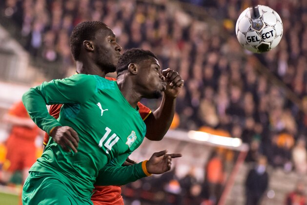 Belgium's Christian Benteke, back, challenges Ivory Coast's Serge Aurier during a friendly soccer match at the King Baudouin stadium in Brussels on Wednesday March 5, 2014. (AP Photo/Geert Vanden Wijngaert)