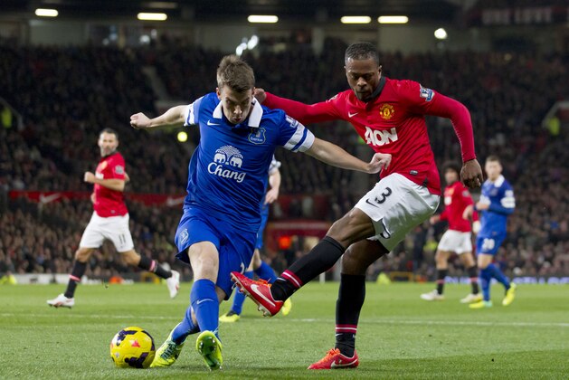 Manchester United's Patrice Evra, right, fights for the ball with Everton's Seamus Coleman during their English Premier League soccer match at Old Trafford Stadium, Manchester, England, Wednesday Dec. 4, 2013. (AP Photo/Jon Super)