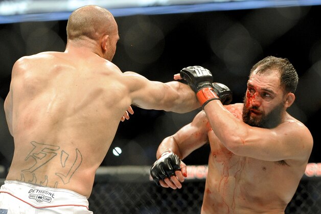 Johny Hendricks blocks a punch from Robbie Lawler during a UFC 171 mixed martial arts welterweight title bout, Saturday, March 15, 2014, in Dallas. Hendricks won by decision. (AP Photo/Matt Strasen)