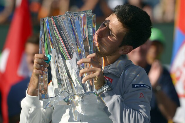 Novak Djokovic, of Serbia, kisses the trophy after he beat Roger Federer, of Switzerland, 3-6, 6-3, 7-6 to win the final match of the BNP Paribas Open tennis tournament, Sunday, March 16, 2014, in Indian Wells, Calif. (AP Photo/Mark J. Terrill)
