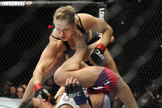 Ronda Rousey of Venice, Calif., punches Miesha Tate of Yakima, Wash., during the UFC 168 mixed martial arts women's bantamweight title fight on Saturday, Dec. 28, 2013, in Las Vegas. Rousey won by a third round tap out. (AP Photo/David Becker)