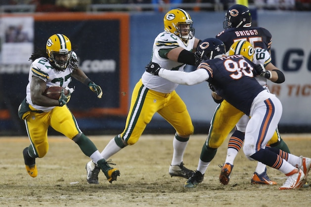 Green Bay Packers running back Eddie Lacy (27) rushes as guard T.J. Lang (70) blocks Chicago Bears defensive end Julius Peppers (90) during the first half of an NFL football game, Sunday, Dec. 29, 2013, in Chicago. (AP Photo/Charles Rex Arbogast)