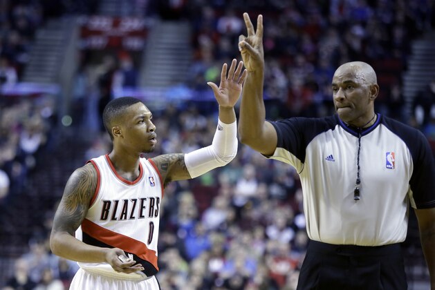 Portland Trail Blazers guard Damian Lillard, left, complains as he is called for a foul by referee Kevin Cutler during the first half of an NBA basketball game against the Washington Wizards in Portland, Ore., Thursday, March 20, 2014. (AP Photo/Don Ryan)