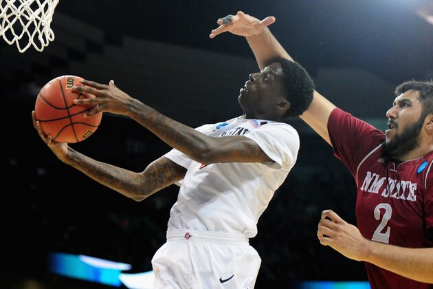 SPOKANE, WA - MARCH 20:  Dwayne Polee II #5 of the San Diego State Aztecs lays up a shot in front of Sim Bhullar #2 of the New Mexico State Aggies during the second round of the 2014 NCAA Men's Basketball Tournament at Spokane Veterans Memorial Arena on March 20, 2014 in Spokane, Washington.  (Photo by Steve Dykes/Getty Images)