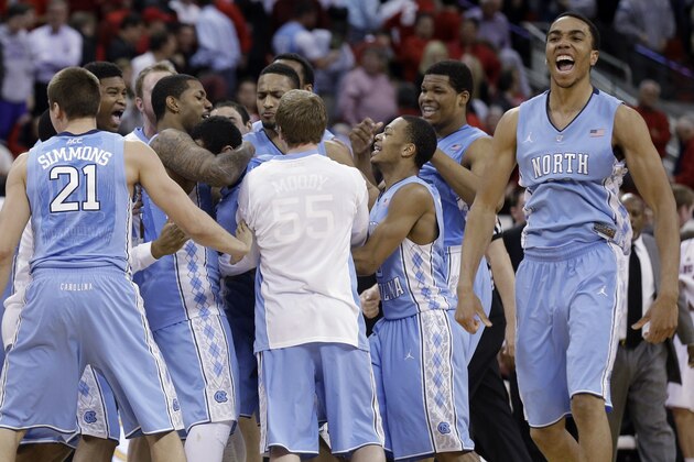 North Carolina's Brice Johnson, right, celebrates as teammates hug Marcus Paige following Paige's shot in overtime following an NCAA college basketball game in Raleigh, N.C., Wednesday, Feb. 26, 2014. North Carolina defeated North Carolina State 85-84 in overtime. (AP Photo/Gerry Broome)
