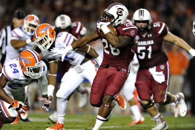 South Carolina running back Mike Davis (28) rushes past Florida's Brian Poole (24) during the first half of an NCAA college football game Saturday, Nov. 16, 2013, at Williams-Brice Stadium in Columbia, S.C. South Carolina won 19-14. (AP Photo/ Richard Shiro) South Carolina running back Mike Davis (28) rushes past Florida's Brian Poole (24) during the first half of an NCAA college football game Saturday, Nov. 16, 2013, at Williams-Brice Stadium in Columbia, S.C. South Carolina won 19-14. (AP Photo/ Richard Shiro)