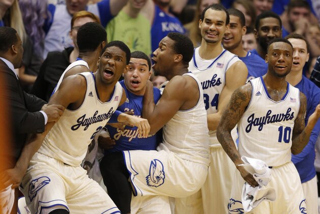 Kansas center Joel Embiid (21) and other players celebrate a basket by teammate Tarik Black during the second half of an NCAA college basketball game in Lawrence, Kan., Saturday, Feb. 22, 2014. Kansas defeated Texas 85-54. (AP Photo/Orlin Wagner)