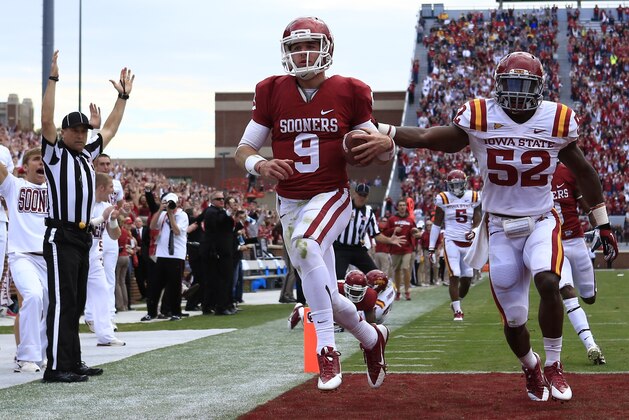 Oklahoma quarterback Trevor Knight (9) runs in for a touchdown in front of Iowa State's Jeremiah George (52) in the third quarter of an NCAA college football game in Norman, Okla. on Saturday, Nov. 16, 2013.  (AP Photo/Alonzo Adams)