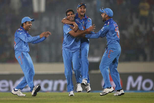 India's Bhuvneshwar Kumar, second left, celebrates with teammates the dismissal of Pakistan's batsman Kamran Akmal during their ICC Twenty20 Cricket World Cup match in Dhaka, Bangladesh, Friday, March 21, 2014. (AP Photo/Aijaz Rahi)