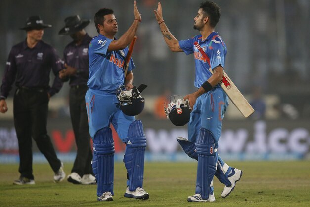 India's batsmen Suresh Raina, second right, and Virat Kohli, right, celebrate their victory over Pakistan in the ICC Twenty20 Cricket World Cup match in Dhaka, Bangladesh, Friday, March 21, 2014. (AP Photo/Aijaz Rahi)