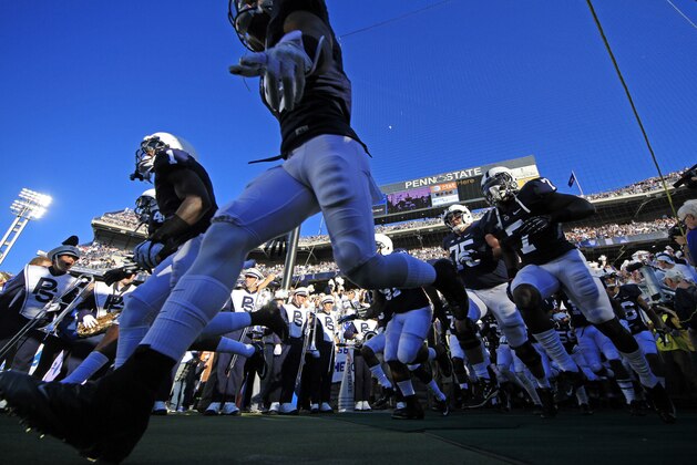 FILE - In this Sept. 14, 2013, file photo, the Penn State football team runs onto the field at Beaver Stadium before an NCAA college football game against UCF in State College, Pa. Penn State will gradually get back football scholarships taken away over the Jerry Sandusky child molestation scandal, the NCAA announced Tuesday, Sept. 24, 2013, crediting the university for making significant improvements to its athletics programs.  (AP Photo/Gene J. Puskar, File)