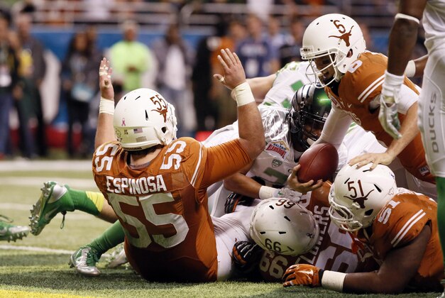 Dec 30, 2013; San Antonio, TX, USA; Texas Longhorns quarterback Case McCoy (top) scores on a 1-yard touchdown run during the first half against Oregon Ducks at Alamo Dome. Mandatory Credit: Soobum Im-USA TODAY Sports