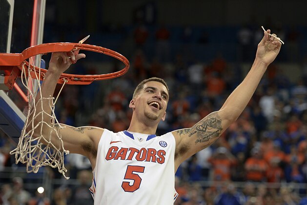 Florida guard Scottie Wilbekin (5) holds up a piece of the net after the Gators became the first team in Southeastern Conference history to go 18-0 in league pla, Saturday, March 8, 2014 in Gainesville, Fla.    Florida defeated Kentucky 84-65 Saturday in an NCAA college basketball game. (AP Photo/Phil Sandlin)