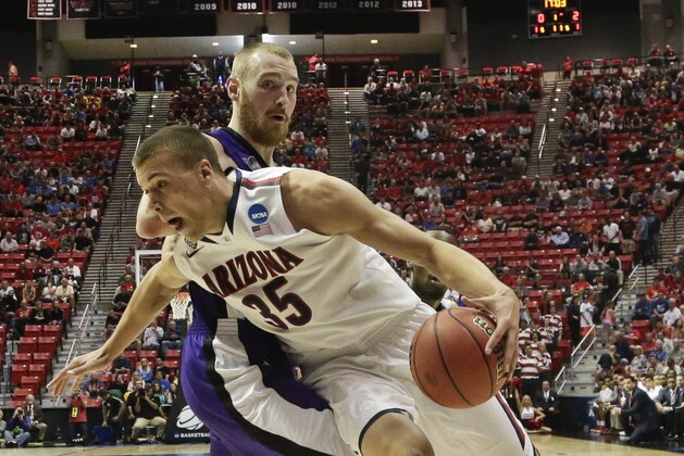 Arizona center Kaleb Tarczewski spins around Weber State center Kyle Tresnak while going to the basket during the first half in a second-round game in the NCAA college basketball tournament Friday, March 21, 2014, in San Diego. (AP Photo/Gregory Bull)