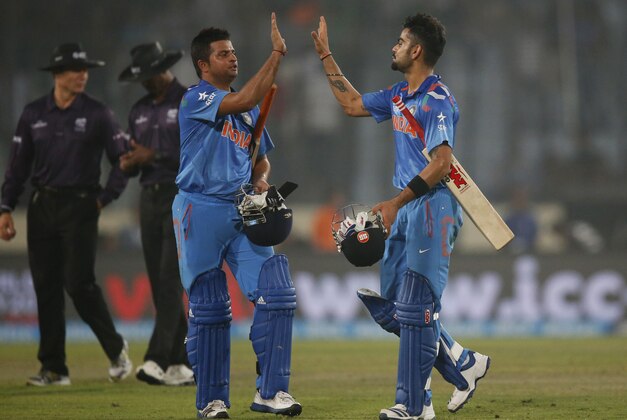 India's batsmen Suresh Raina, second right, and Virat Kohli, right, celebrate their victory over Pakistan in the ICC Twenty20 Cricket World Cup match in Dhaka, Bangladesh, Friday, March 21, 2014. (AP Photo/Aijaz Rahi)