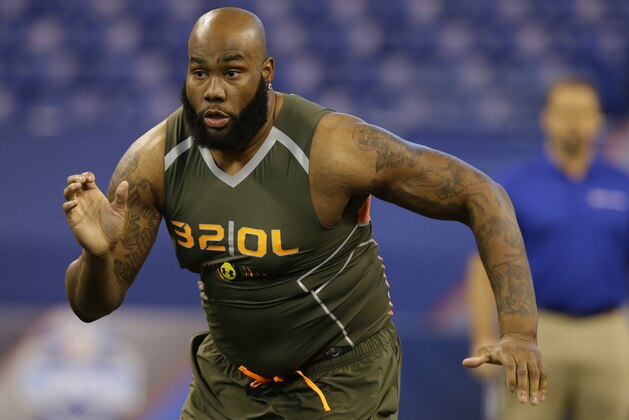 Virginia offensive lineman Morgan Moses runs a drill at the NFL football scouting combine in Indianapolis, Saturday, Feb. 22, 2014. (AP Photo/Michael Conroy)