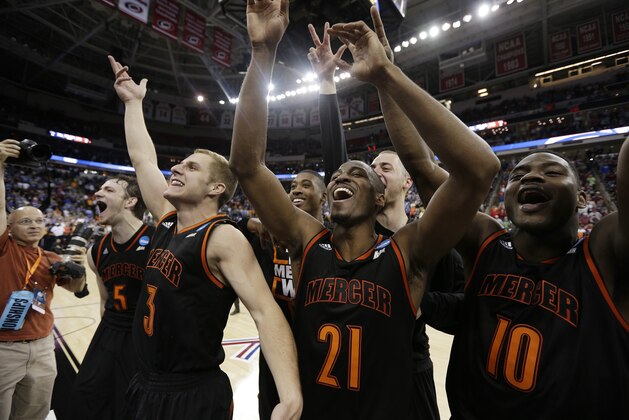 Mercer guard Langston Hall (21) and other Mercer players celebrate after the second half of an NCAA college basketball second-round game against Duke, Friday, March 21, 2014, in Raleigh, N.C. Mercer won 78-71. (AP Photo/Chuck Burton)