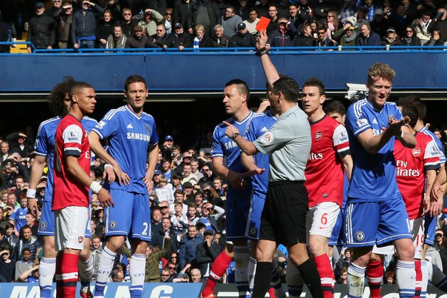 Referee Andre Marriner, in grey, sends off Arsenal's Kieran Gibbs, left, during their English Premier League soccer match between Chelsea and Arsenal at Stamford Bridge stadium in London Saturday, March 22  2014. (AP Photo/Alastair Grant)