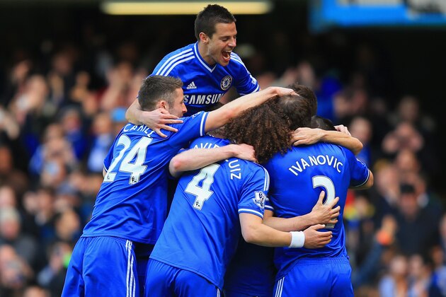 LONDON, ENGLAND - MARCH 22:  Eden Hazard of Chelsea is mobbed by team mates after scoring their fourth goal from the penalty spot during the Barclays Premier League match between Chelsea and Arsenal at Stamford Bridge on March 22, 2014 in London, England.  (Photo by Richard Heathcote/Getty Images)
