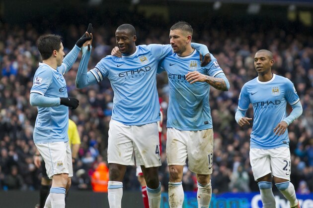 Manchester City's Yaya Toure, centre, celebrates with teammates after scoring his third goal against Fulham during their English Premier League soccer match at the Etihad Stadium, Manchester, England, Saturday March 22, 2014. (AP Photo/Jon Super)