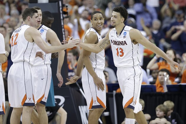 Virginia forward Anthony Gill (13) shakes hands with Virginia guard Joe Harris (12) during the second half of an NCAA college basketball second-round tournament game, Friday, March 21, 2014, in Raleigh. (AP Photo/Gerry Broome)