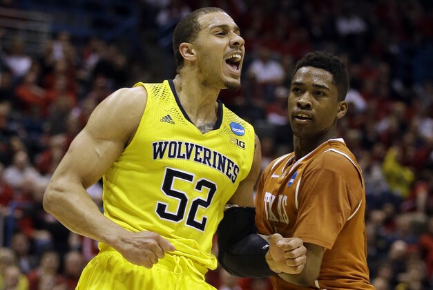Michigan forward Jordan Morgan (52) reacts to a foul call as Texas guard Isaiah Taylor watches him during the second half of a third-round game of the NCAA college basketball tournament Saturday, March 22, 2014, in Milwaukee. (AP Photo/Jeffrey Phelps)